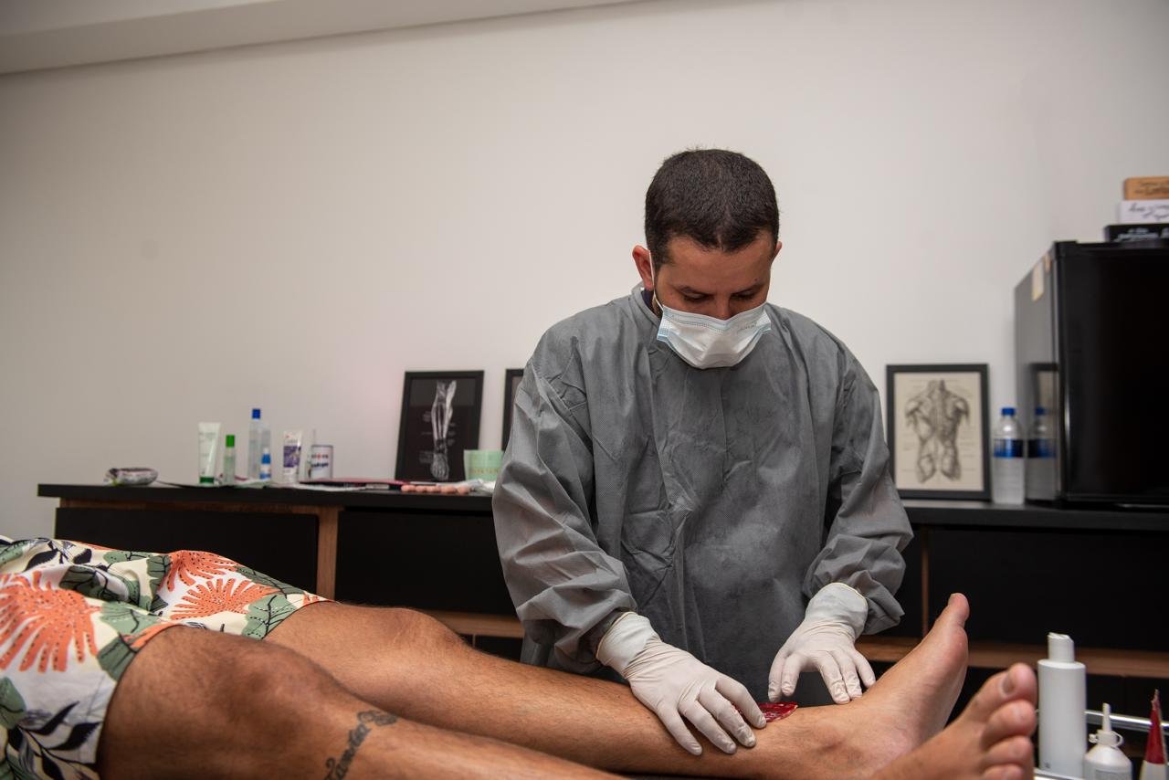 Enfermeiro Theo Lourenço atendendo paciente